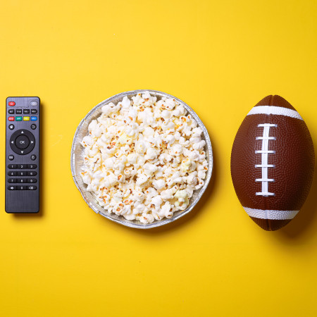 Bowl of popcorn, a football and a remote